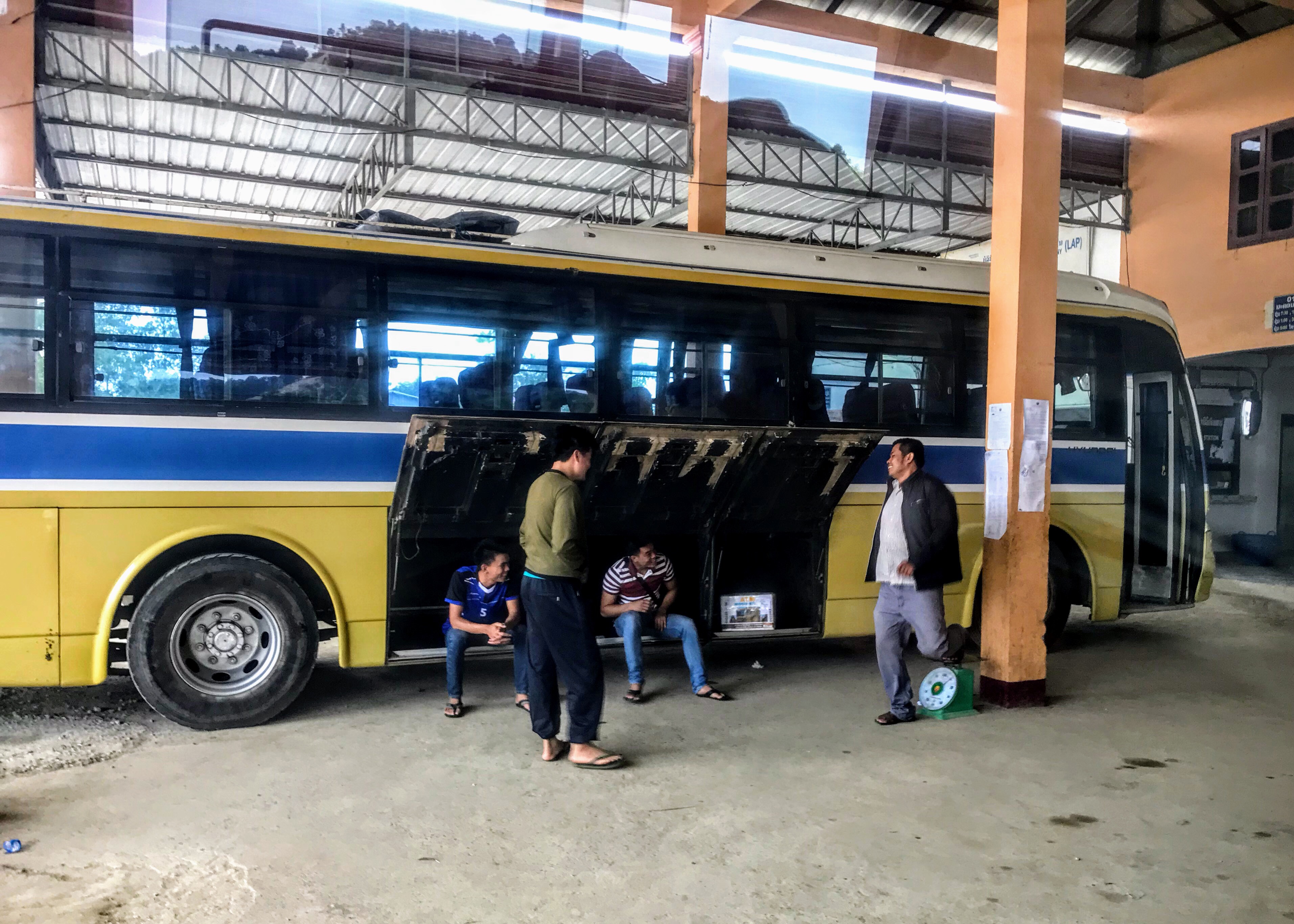 Men weighing themselves at Xam Neua bus station 