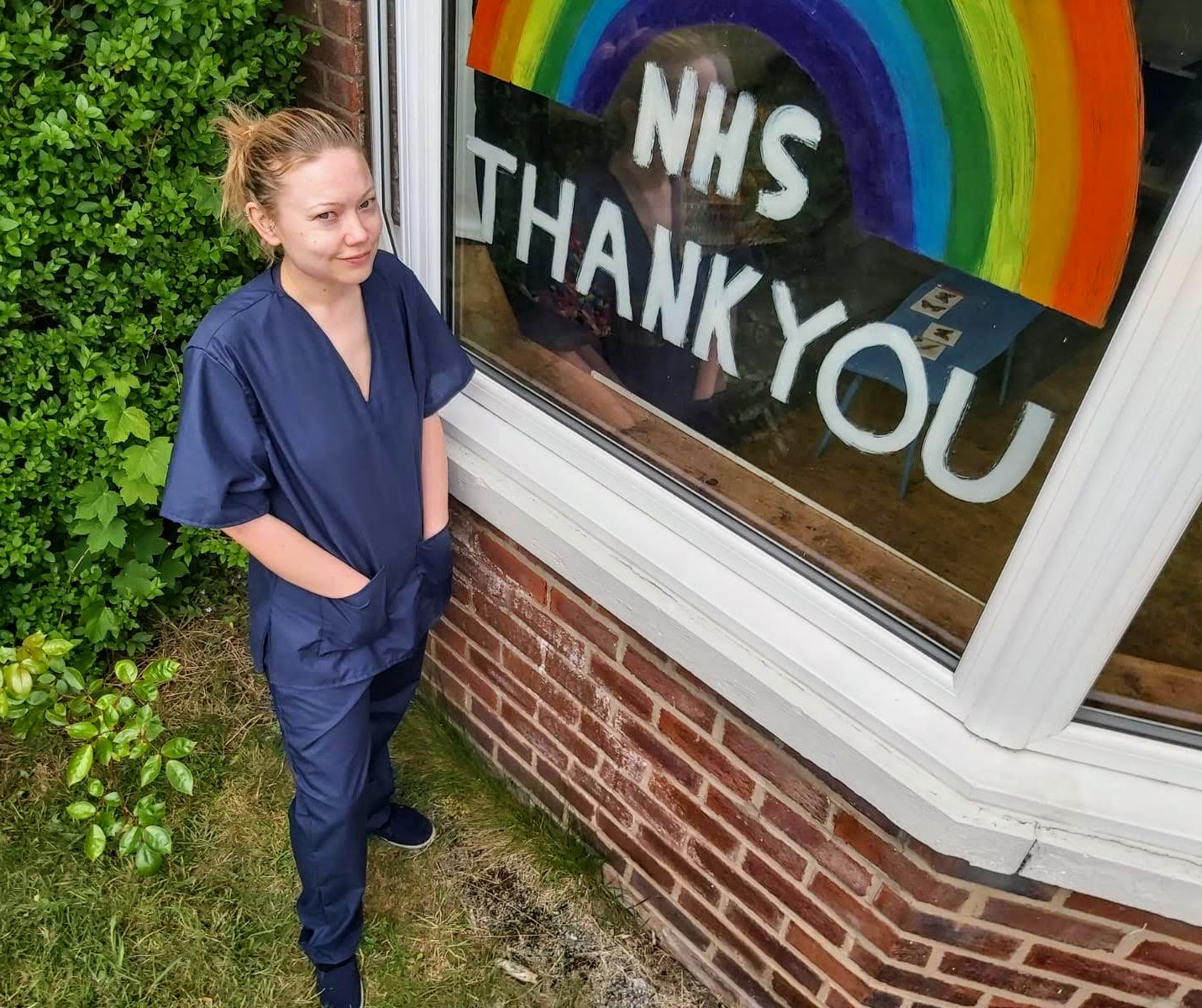 Wearing scrubs next to a rainbow