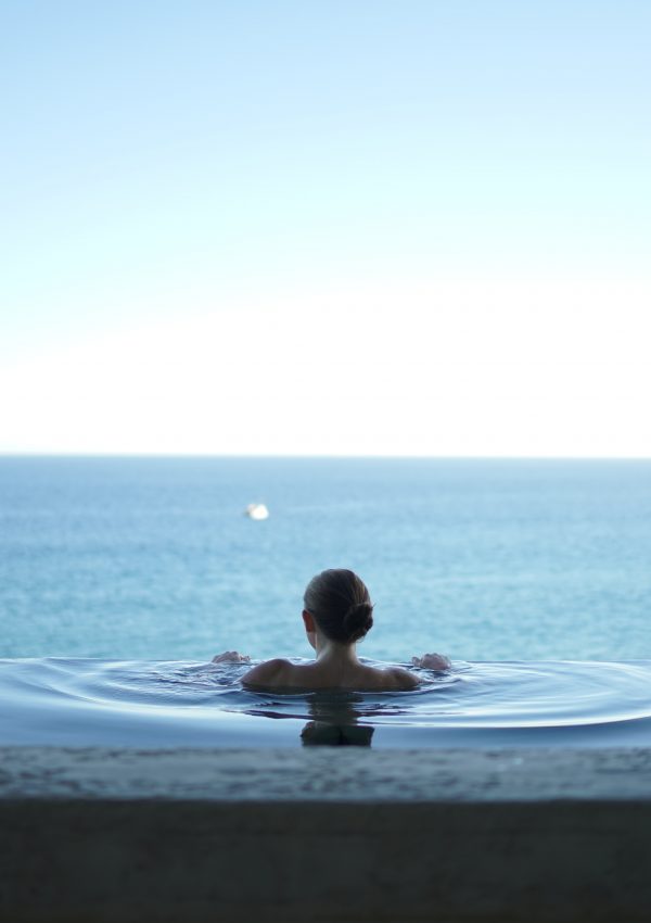 Woman in an infinity pool in Mexico. Photo by Alex Bertha on Unsplash.