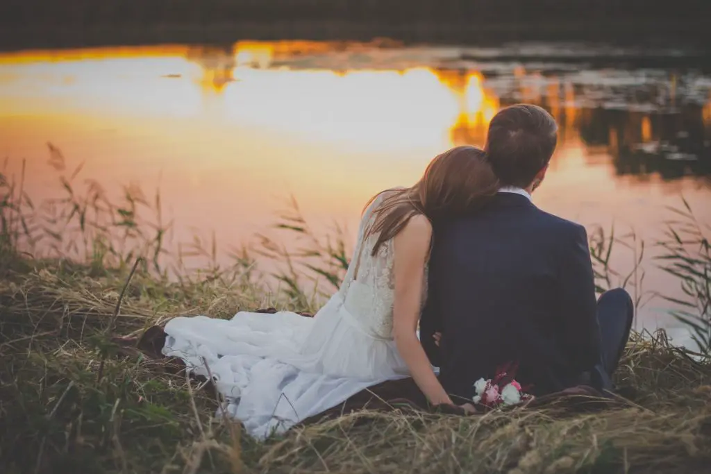 Wedded couple looking at a lake. Photo by freestocks on Unsplash.