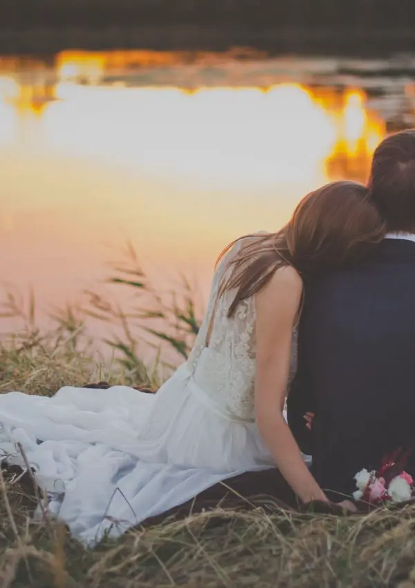 Wedded couple looking at a lake. Photo by freestocks on Unsplash.
