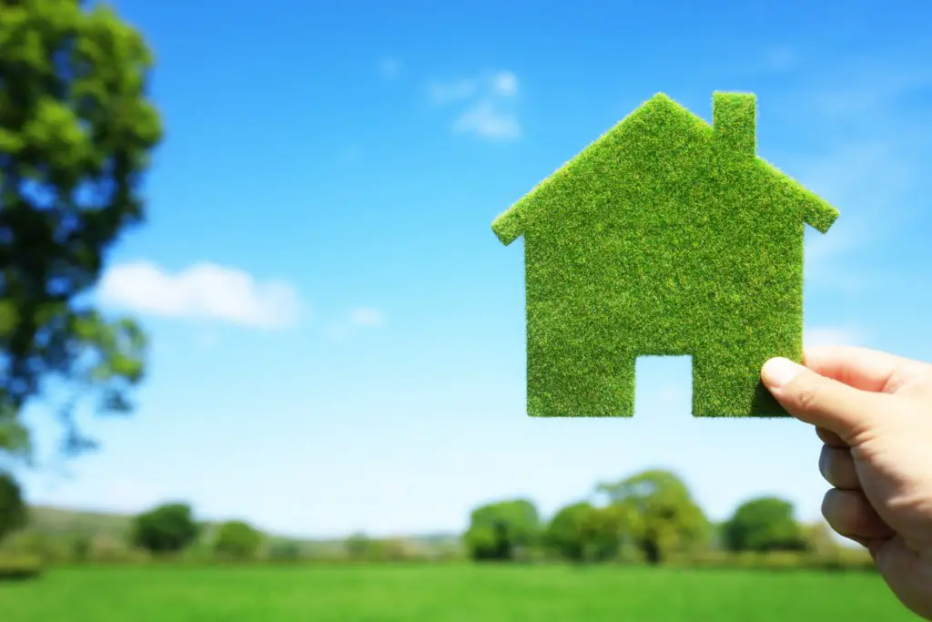 Green eco house in an empty field.